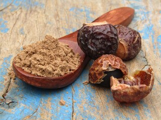 Sapindus mukorossi or Indian soapberry powder on wooden spoon 