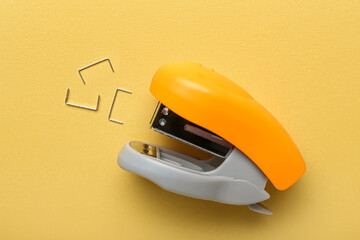 Office stapler with staples on color background