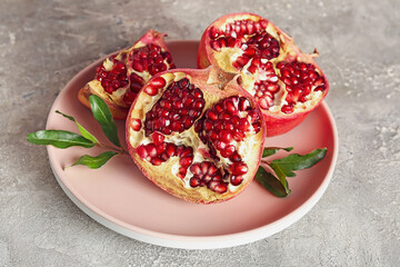 Obraz na płótnie Canvas Plate of fresh pomegranates on grunge background