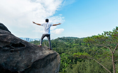 Man on top of the mountain with raised hands