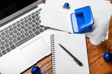 Office stationery with laptop and Christmas balls on wooden background