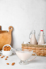 Gravy boat of almond milk on light background