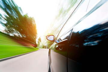 Mirror view of speeding car with blurred road