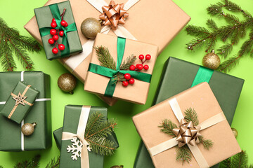 Christmas gifts with balls and fir branches on green background