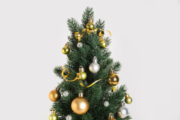 Small Christmas tree with balls on light background, closeup