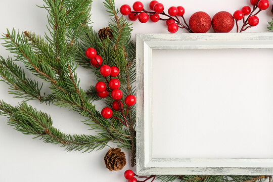 Frame with Christmas branches and rowan on white background