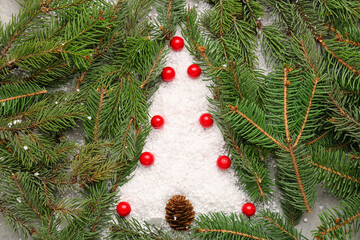 Naklejka na ściany i meble Christmas tree made of fir branches, rowan and cone on snow