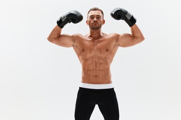 Man athletic bodybuilder poses in boxing gloves with nude torso abs in full-length background, boxing and martial arts. Advertising, sports, active lifestyle, competition, challenge concept. 