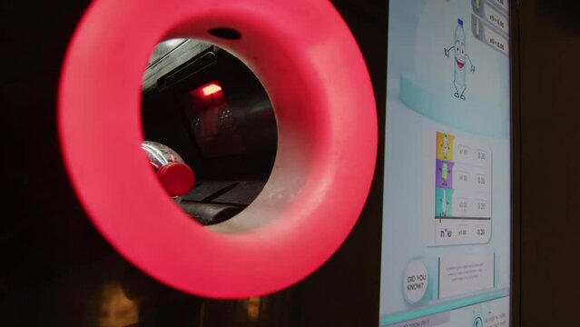 Putting plastic bottle in recycling system, scanning barcode in recycle bin
