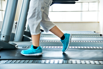 Young boy legs walking on treadmills in gym