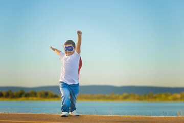 Obraz premium Portrait of adorable kid boy having fun outdoor. Little child play superhero