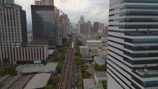 Close to the skyscraper over the train on railroad track. Calm aerial view flight fly push in drone
bangkok city ari thailand, dezember 2022. 4k marnitz Cinematic