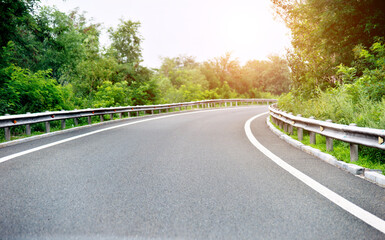 Obraz premium Asphalt road through the deep forest