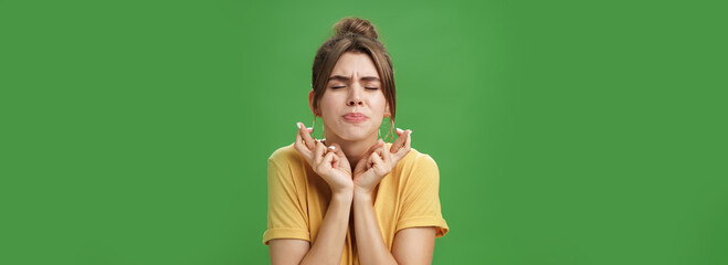 Worried intense, concerned attractive young european female model in yellow t-shirt raising...