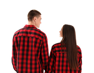 Young couple in checkered pajamas on white background, back view