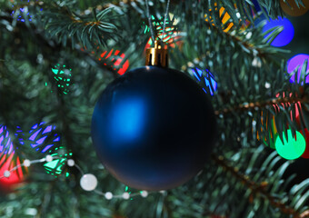 Obraz na płótnie Canvas Blue Christmas ball on fir tree at night, closeup