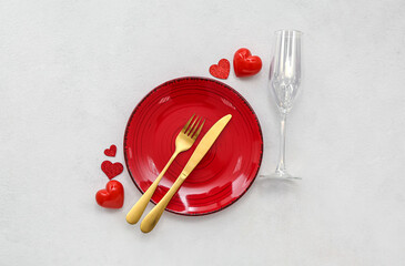 Table setting for Valentine's Day with red hearts on grey background