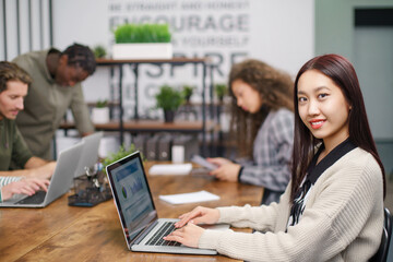 portrait of a young business woman at a table in a coworking center.