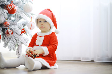 Merry bright christmas. Lovely baby enjoy christmas. Childhood memories. Santa girl little child celebrate christmas at home. Family holiday. Girl cute child cheerful mood play near christmas tree.
