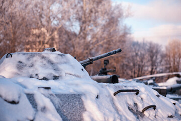 Tank under the snow in the forest. Winter tank camouflage. Battle tank in the snow on the roadside...