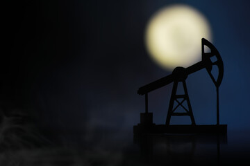 The crank balanced beam pumping unit under the curtain of night. Beam pumping unit under the night, closeup of photo