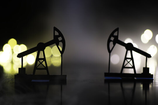 The crank balanced beam pumping unit under the curtain of night. Beam pumping unit under the night, closeup of photo