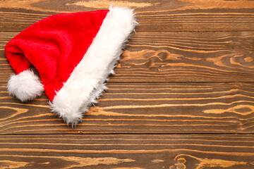 Obraz na płótnie Canvas Red Santa hat on wooden background