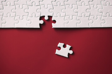 Clean puzzle elements on the red background. Empty puzzle piece on the table. Teamwork concept.