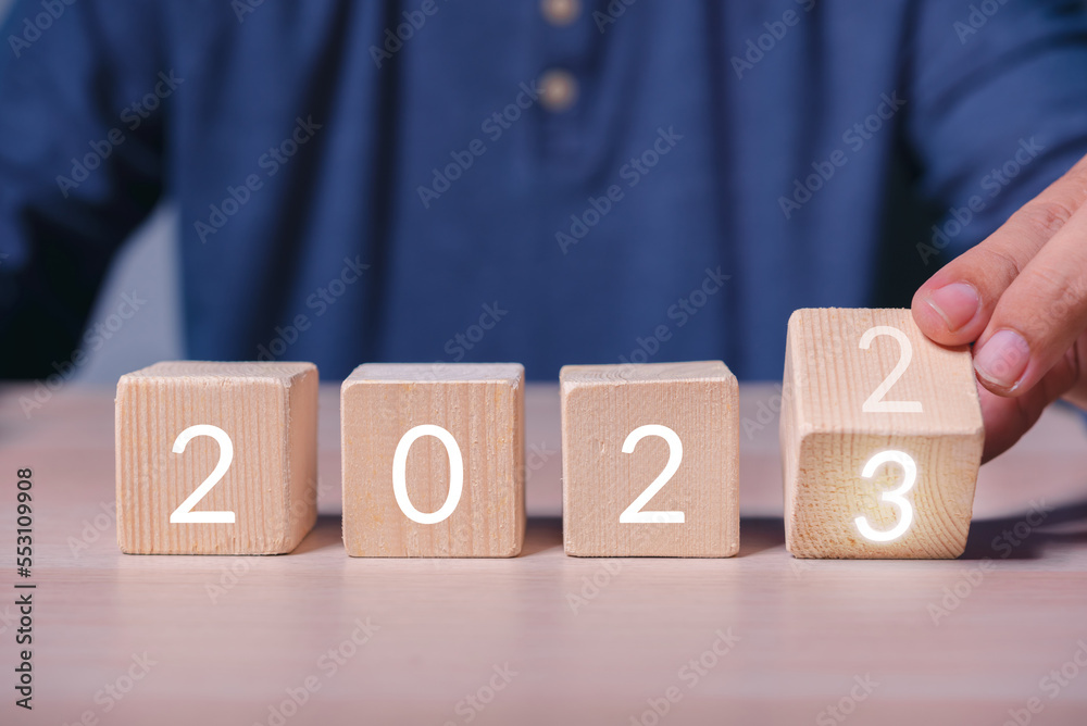 Aufkleber hand build stack of wood cube building block with text 2023 , new year 2023 plan concept