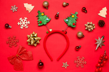 Composition with funny Christmas headband and beautiful decorations on red background