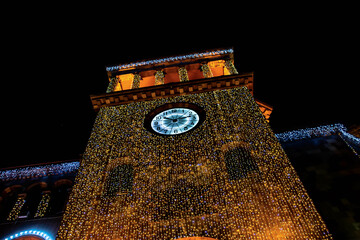 Glowing building tower and huge clock. Beautiful building architecture. The walls of the building...