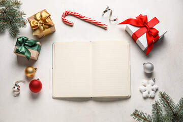 Composition with blank open notebook, Christmas gifts, decorations and fir branches on light background