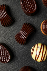 Chocolate candies on black wooden board, closeup