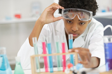 close-up of professional female scientist in protective eyeglasses