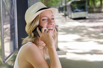 woman on phone waiting for bus