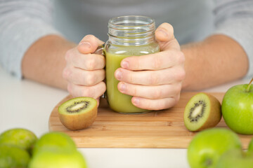 young man male making a green smoothie cocktail