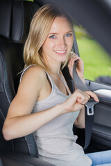 Obraz na płótnie Canvas passenger woman fastening seat belt in the car