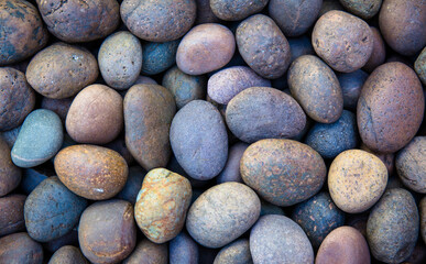 small smooth waterworn black pebbles or stones for use decor and garden landscaping. tone garden interiors. stone spa