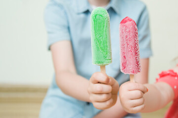 Little girl and boy eats ice cream. The child enjoys ice cream in the summer. Happy childhood...