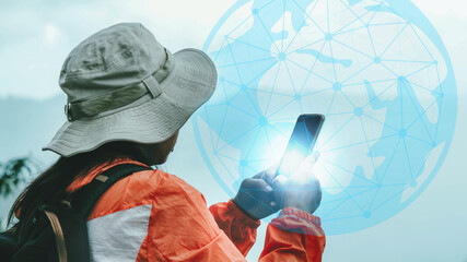 Female ecologists carry a backpack using a map on the phone to explore the forest path. Female...