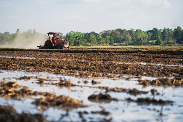 Fototapeta premium Agricultural tractors are plowing the soil in preparation for planting.
