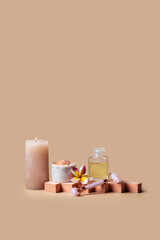 Holistic skin care still life . Natural oil bottle , salt scrab,gua sha roller, and frangipani flower on the podium at beige backgrond. Wellness center and spa salon concept.Copy space