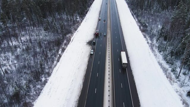 Insured event - a burned-out car on a road outside the city, aerial view. Near the fire and police cars. Help and rescue concept, 911 service. White snow on the side of the road. UHD 4K