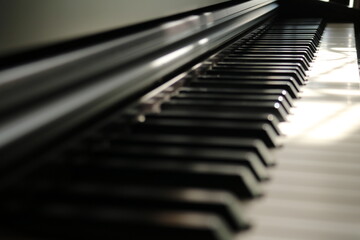 Naklejka premium Sunlight on Piano, keyboard close up instrument playing music, practing and celebrate. Side view of keys