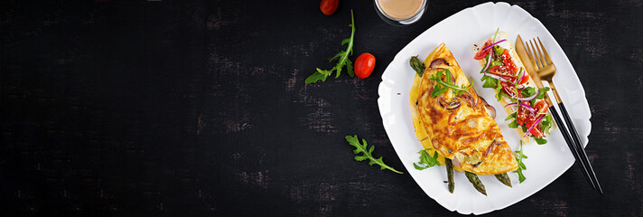 Keto breakfast. Omelette with cheese, red onion and asparagus on dark table. Italian frittata. Keto, ketogenic lunch. Top view, banner
