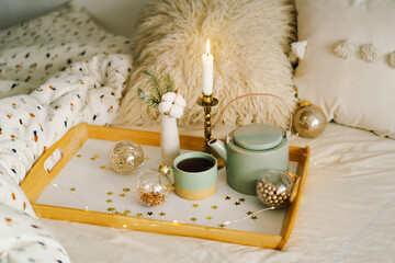 Obraz na płótnie Canvas Hot tea, candle, Christmas golden balls and decorations. Christmas holiday mood in home. Winter concept.
