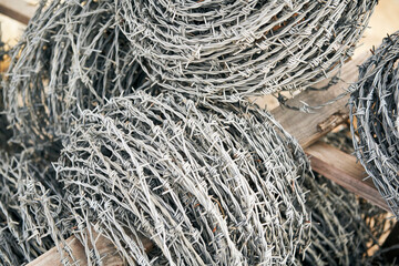 Barbed wire metal border barrier security warning.