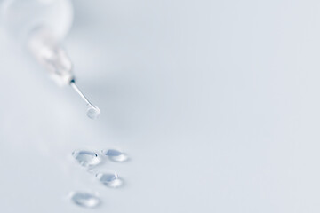 Syringe with injection over blue background. Vaccination or beauty therapy concept.