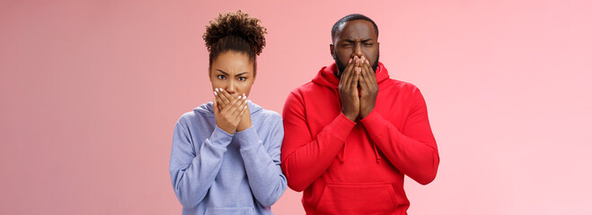 Romantic couple african american boyfriend girlfriend feel sick after eating dinner restaurant press palms mouth frowning wanna puke vomit, standing disgusted shocked pink background - obrazy, fototapety, plakaty