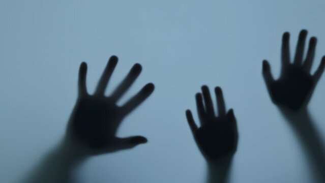 Shadow of the hands knock on the window, blur. Murderer, killer or robber